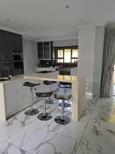 una cocina con suelo de mármol y taburetes de bar en Charis on Beaumont Home en Ramsgate