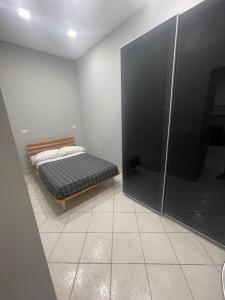 um quarto com uma cama e uma cabina de duche ao nível do chão em La perla di Napoli e della Costiera em San Vitaliano 