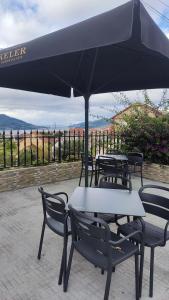 un groupe de tables et de chaises sous un parapluie dans l'établissement Jumboli, à Redondela