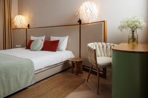 um quarto com uma cama, uma mesa e uma cadeira em Aries' Collection Luxury Suites em Braşov