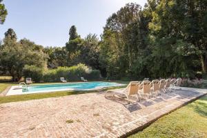 a group of chairs sitting next to a swimming pool at Agriturismo Tenuta Castel Venezze in San Martino di Venezze