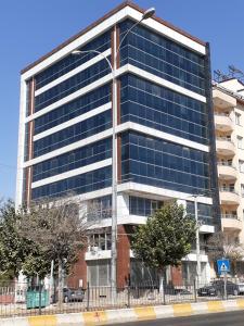 un edificio de oficinas con ventanas azules en una calle en GrandPazarcıkOtel, 