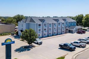 un gran edificio con coches estacionados en un estacionamiento en Days Inn & Suites by Wyndham Greeley en Greeley