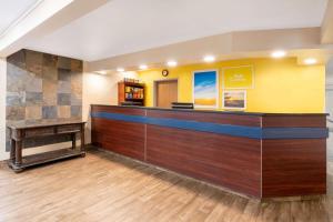 vestíbulo del hotel con mostrador de recepción y escritorio en Days Inn & Suites by Wyndham Greeley en Greeley