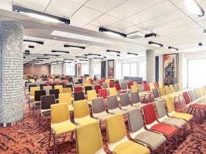 Cette grande chambre comprend des rangées de chaises et de tables. dans l'établissement Mercure Wrocław Centrum, à Wrocław