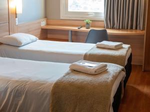 2 posti letto in camera d'albergo con asciugamani sui sedili di ibis Concepcion a Concepción