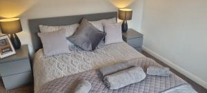 um quarto com uma cama com almofadas e 2 candeeiros em Swindon 6 deluxe doubles 2 with en suite in large house em Swindon