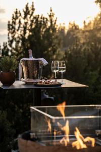 アルペ・ディ・シウージにあるHotel Rosa Eco Alpine Spaのティーケトルとグラスワインのあるテーブル