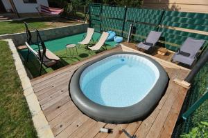 a hot tub on a deck next to a swimming pool at Vila Banstolija in Velika Remeta