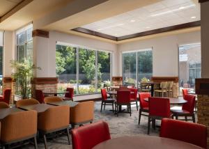 um restaurante com mesas, cadeiras e janelas em Hilton Garden Inn Ann Arbor em Ann Arbor