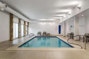 a swimming pool in a room with chairs and tables at DoubleTree by Hilton Pittsburgh Airport in Moon Township