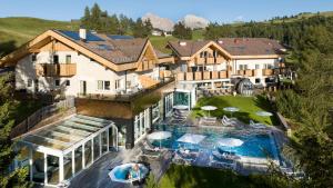 アルペ・ディ・シウージにあるHotel Rosa Eco Alpine Spaのプール付きの家の航空写真