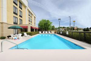 a large swimming pool with chairs and a building at Hampton Inn Spartanburg Hotel in Spartanburg