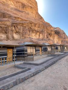 a building in front of a rocky mountain at Zawaideh desert Camp in Wadi Rum