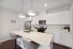 cocina con armarios blancos y encimera blanca en Spacious 3Bedroom Duplex with Rooftop Deck!, en Washington