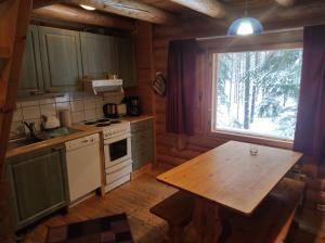 a kitchen with a table and a window in a cabin at Kalliorinteen Mökit Ruskapirtti in Töysä