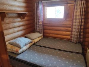 Habitación con 2 camas en una cabaña de madera en Kalliorinteen Mökit Ruskapirtti en Töysä