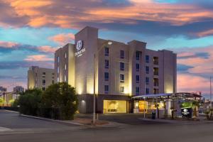 ラスベガスにあるDoubleTree by Hilton Las Vegas East Flamingoの夕暮れ時のガソリンスタンド付きホテルの建物