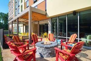 un patio con sillas rojas y una hoguera en Home2 Suites By Hilton Richmond Glenside en Richmond