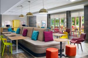 uma sala de estar com um sofá, mesas e cadeiras em Home2 Suites By Hilton Richmond Glenside em Richmond
