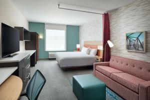 リッチモンドにあるHome2 Suites By Hilton Richmond Glensideのベッドとソファのあるホテルの部屋