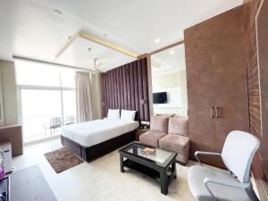 Hotel TBS sea view ! Puri Swimming-pool, fully-air-conditioned-hotel with-lift-and-parking-facility breakfast-included في بوري: غرفه فندقيه بسرير واريكه