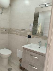 un bagno con un water, un lavandino e uno specchio di City Wonders B&B a Napoli