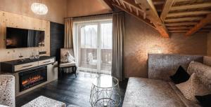 アルペ・ディ・シウージにあるHotel Rosa Eco Alpine Spaのソファと暖炉のあるリビングルーム