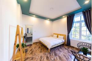 a bedroom with a bed and a large window at Trà My Villa Đà Lạt BBQ Garden - Nguyên Căn Có Sân Vườn in Da Lat