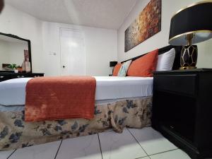 um quarto com uma cama grande e um cobertor vermelho em Beach One Bedroom 2 em Ocho Rios