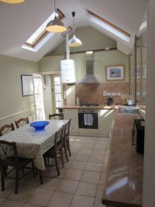 a kitchen with a table and some chairs and a kitchen with at Darcus Cottage in Derry Londonderry