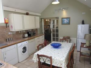 a kitchen with a table with a blue bowl on it at Darcus Cottage in Derry Londonderry