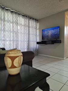 a living room with a vase on a table at Beach One Bedroom 2 in Ocho Rios