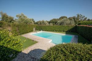 a swimming pool in a garden with bushes at Villa Marilì in Bracciano
