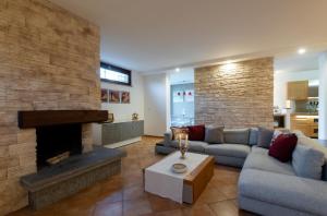 Villa Marilì في براتشيانو: غرفة معيشة مع أريكة ومدفأة