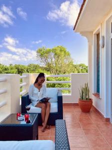 una mujer sentada en una silla en un balcón en Hilda's Homestay, en Diani Beach