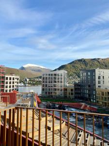 Blick auf eine Stadt mit Gebäuden und Bergen in der Unterkunft TotalApartments Vervet Gjøa, brand new apartments in Tromsø
