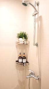 y baño con ducha y 2 botellas en un estante. en R Home Staycation - Niagara Tower en Manila