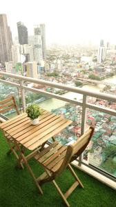 una mesa de madera y una silla en un balcón con vistas en R Home Staycation - Niagara Tower en Manila