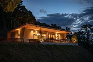 Una casa se ilumina por la noche en SOOTHE FOREST en Shio