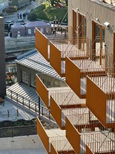 an image of a building with orange stairs at TotalApartments Vervet Gjøa, brand new apartments in Tromsø