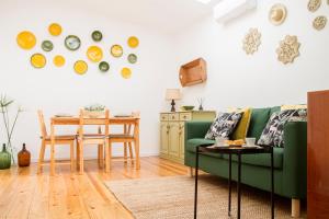 ein Wohnzimmer mit einem grünen Sofa und einem Tisch in der Unterkunft Casa da Avó Guilhermina in Leiria