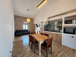 een keuken en een woonkamer met een houten tafel en stoelen bij Luz Do Sul Holiday Rental - Pedras in Moncarapacho