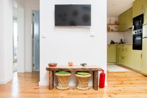 eine Küche mit einem Holztisch mit zwei Hockern in der Unterkunft Casa da Avó Guilhermina in Leiria