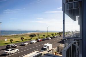 a view of a highway with cars parked on the beach at Mouille Point Places - Studios & Apartments in Cape Town