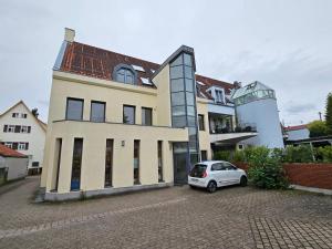 une voiture blanche garée devant un bâtiment dans l'établissement Maisonette-Wohnung Airport/Messe Stuttgart - Balkon - Parkplatz - Netflix, à Leura