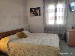 a bedroom with a bed with a comforter and a window at Casa Patrizia B&B cir in info in Sirmione