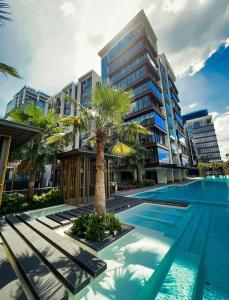 an apartment building with a swimming pool and a palm tree at THE CREST-Central Saigon Riverside -Free POOL-GYM-SAUNA Room-YOGA Room in Ho Chi Minh City