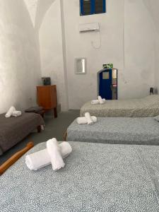 a room with three beds with towels on them at Poudras Amazing View Caldera in Órmos Athiniós +13 photos