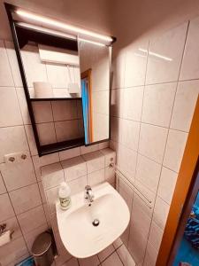 a white bathroom with a sink and a mirror at The Room - Direkt in der Stadt! in Bochum